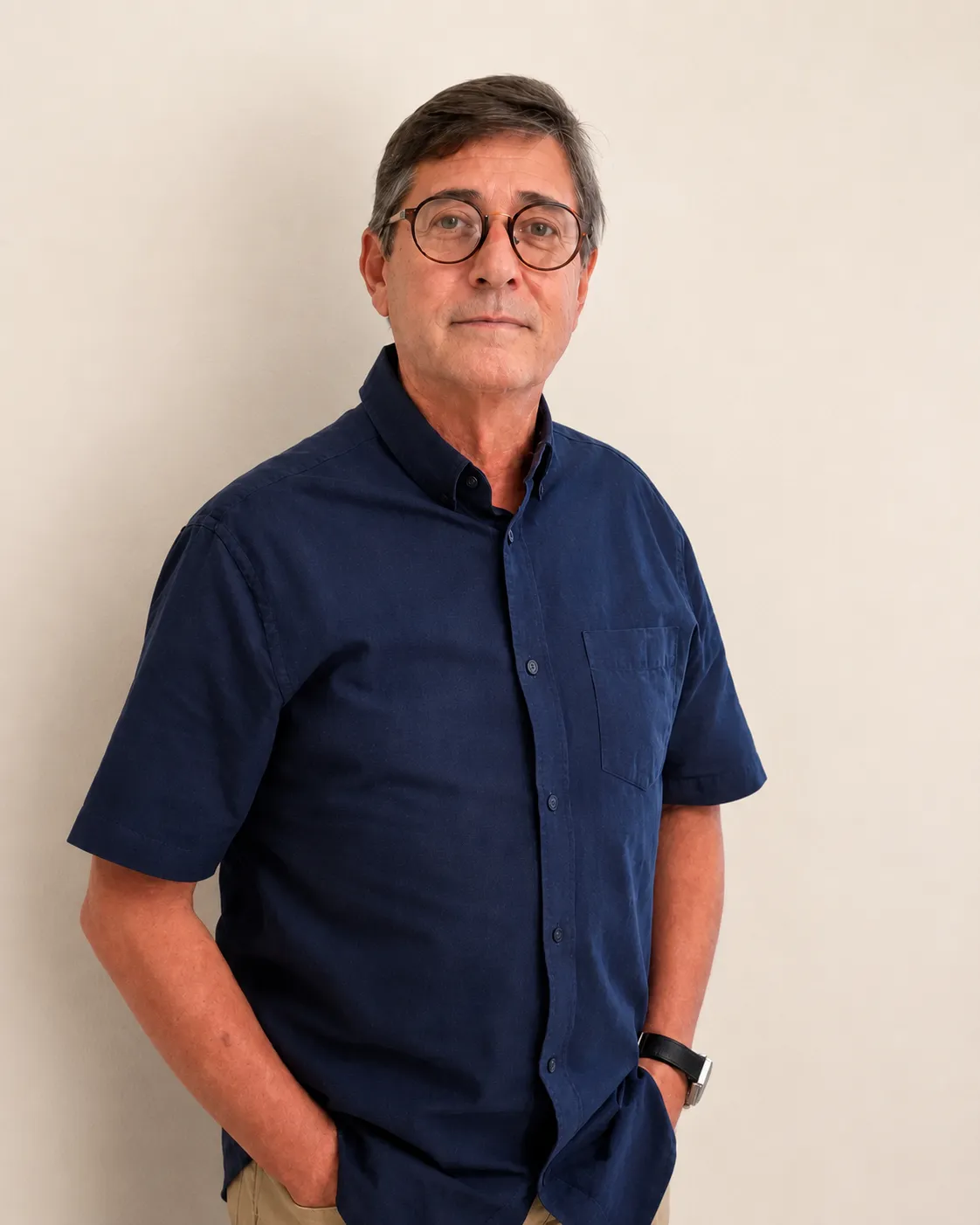 Psicanalista Jayr Santos de pé com camisa azul em seu consultório